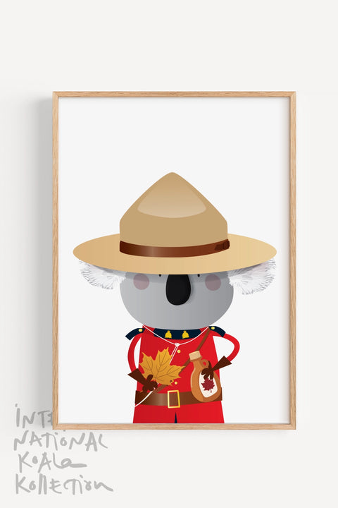 A framed souvenir print featuring a koala dressed as a member of the Royal Canadian Mounted Police, holding a maple leaf and a jar of maple syrup, designed for Canadians in Australia